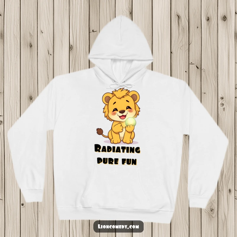 Funny hoodie featuring a lion cub giggling while holding a small, glowing magical orb, perfect for warmth and whimsical charm.