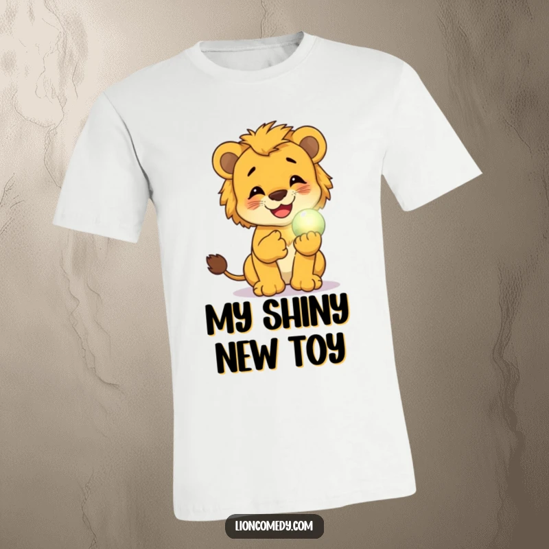 Funny t-shirt of a lion cub giggling adorably while holding a small, glowing magical orb, exuding whimsical delight.
