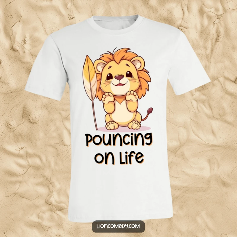 Funny t-shirt with a small, adorable lion cub poised to pounce with its front paws up, targeting a playful feather.