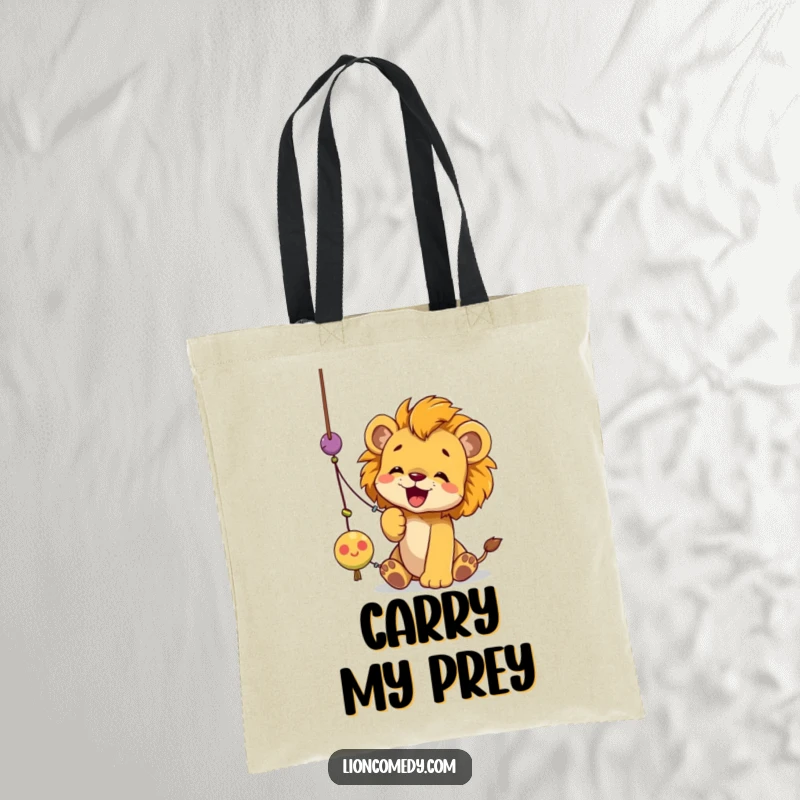 Funny lion cub tote bag depicting a cub joyfully batting at a dangling string toy with its paws, full of playful energy.